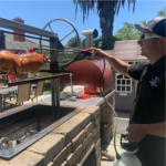Cooking on a charcoal grill with adjustable rotisserie for whole hog