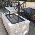 An all iron grill frame insert installed into a brick outdoor island.